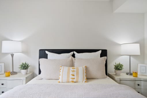 a bedroom with a bed and pillows and two night stands