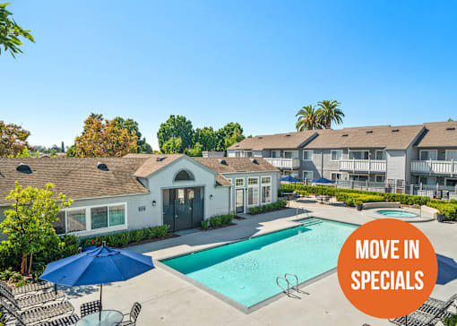A pool surrounded by chairs and umbrellas with a sign that says "Move in Specials".