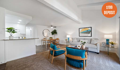 A living room with a white couch, a blue chair, and a white coffee table.