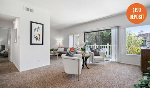 A living room with a white sofa and a painting on the wall.