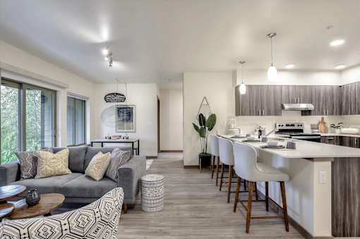 A modern living room with a grey sofa and a wooden floor.