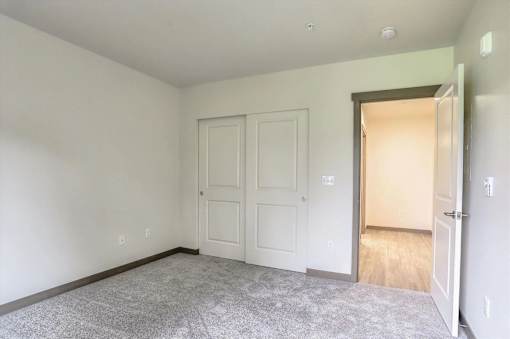 A room with a grey carpet and a white door.