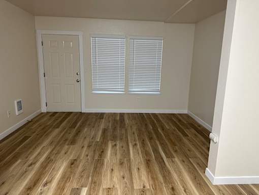 A room with wooden flooring and a white door.