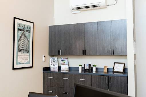 A framed picture of the Seattle Hotel is on the wall above a desk.