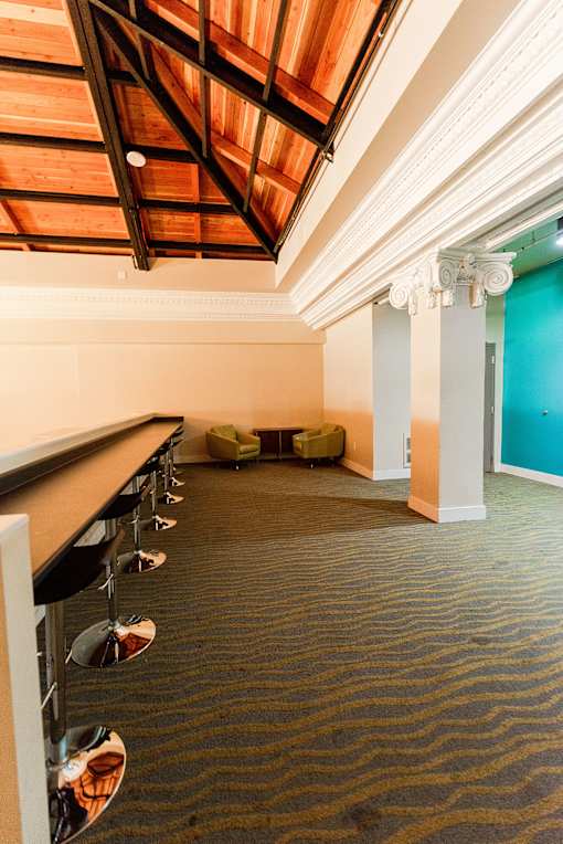 A room with a carpeted floor and a long table with chairs.