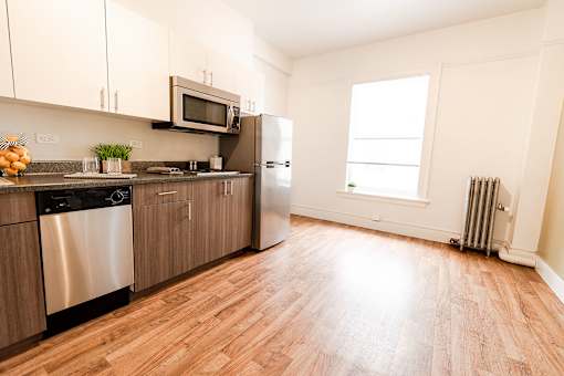 A kitchen with wooden floors and stainless steel appliances.
