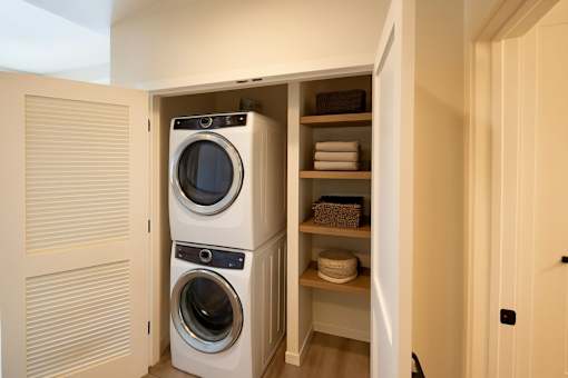 A washing machine is in a cabinet in a room.
