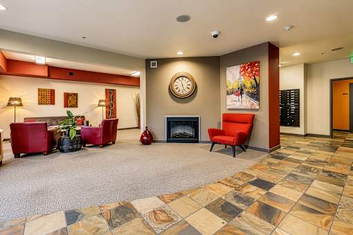 A living room with a fireplace and a clock on the wall.