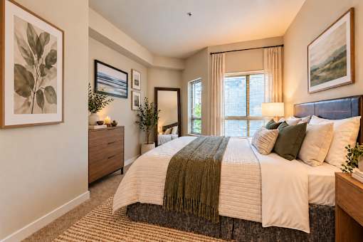 A bedroom with a large bed and a painting on the wall.