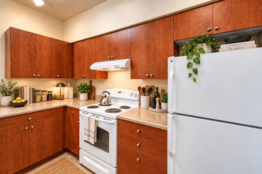 A kitchen with wooden cabinets and a white refrigerator.