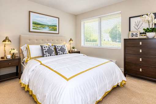 A bedroom with a large bed and a painting on the wall.