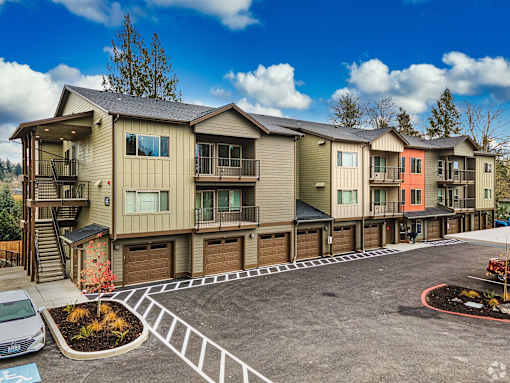 A row of townhouses with a car parked in front of the first one.