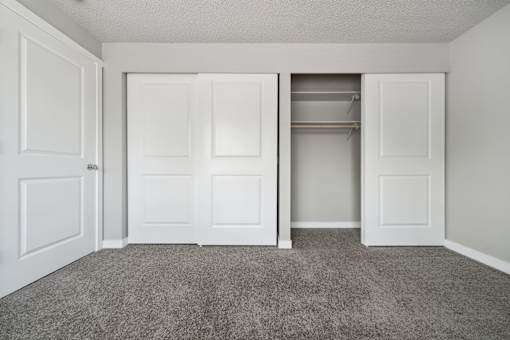 A room with white doors and a carpeted floor.
