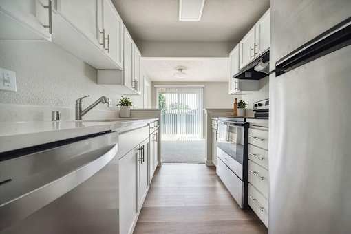 A modern kitchen with white cabinets and stainless steel appliances.