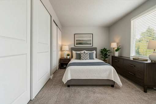 A bedroom with a bed, nightstands, and a window with blinds.