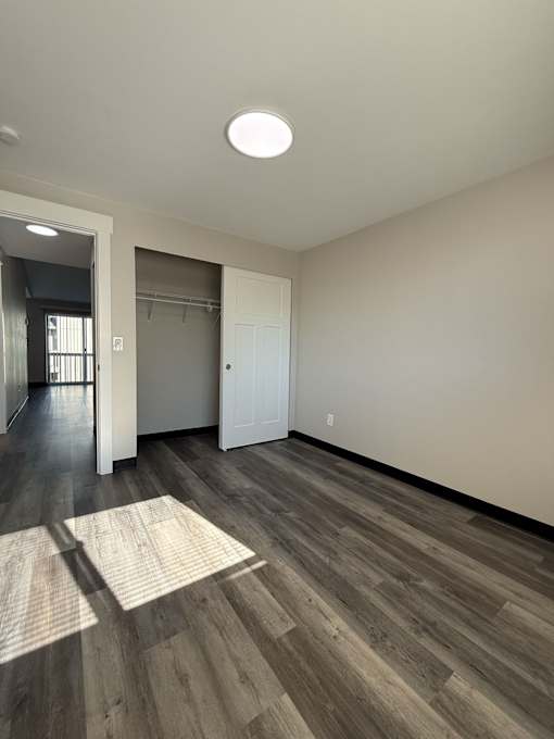 A room with a light on the ceiling and a rug on the floor.