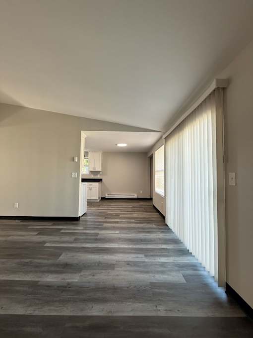 A long hallway with a kitchen visible in the distance.