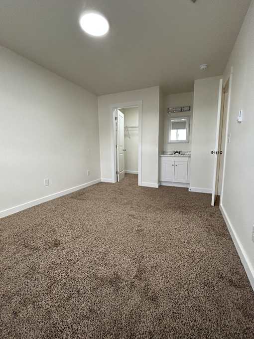 A room with carpeted floor and white walls.