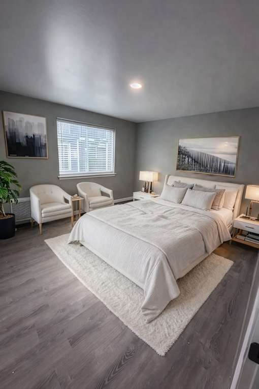 A bedroom with a large bed and a chair.