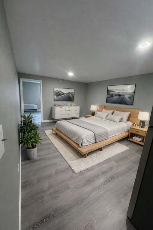 A modern bedroom with a large bed and a potted plant.