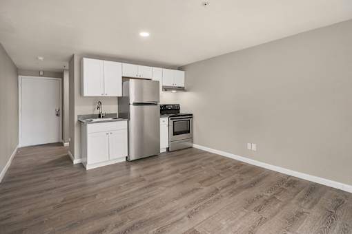 A kitchen with a refrigerator, oven, and sink.