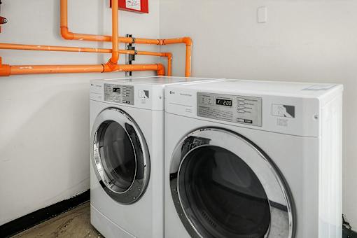 Two front load washing machines in a laundry room.
