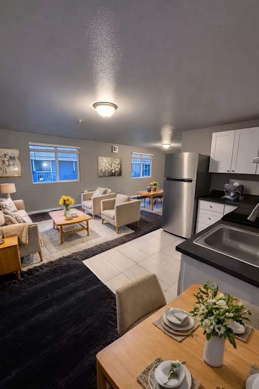 A modern kitchen with a dining table set for two.