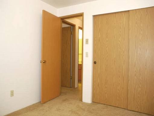 A room with a brown door and a white wall.