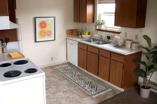 A kitchen with a stove top oven and a sink.