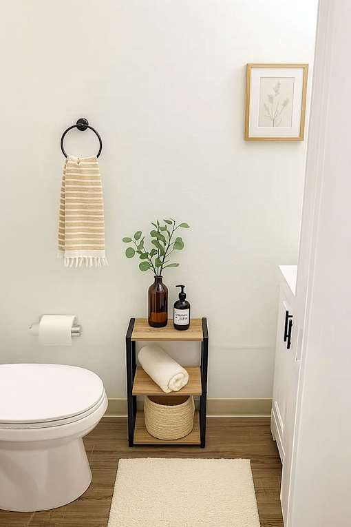 A bathroom with a toilet, a towel rack with a towel and a plant on it.