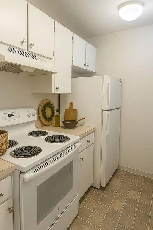 A white kitchen with a stove, oven, and refrigerator.
