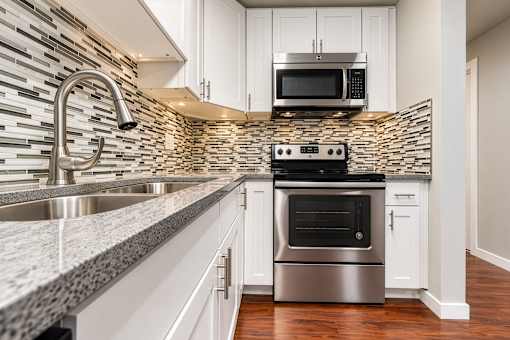 A modern kitchen with a stainless steel oven and a microwave above it.