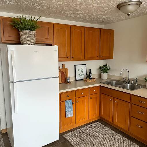 A white fridge in a kitchen with wooden cabinets.