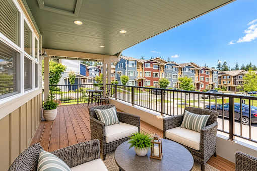 A balcony with a table and chairs overlooking a row of houses.