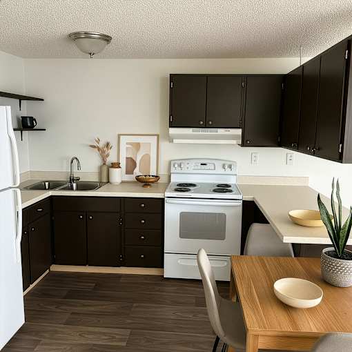 A kitchen with a white stove top oven and black cabinets.