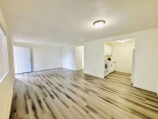 A room with wooden flooring and white walls.