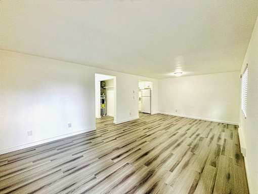 A room with wooden flooring and white walls.