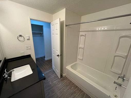 A bathroom with a sink, bathtub, and shower.