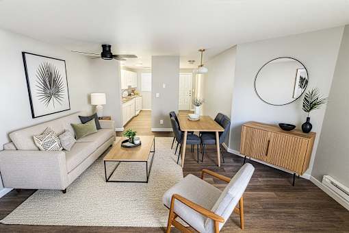 A living room with a couch, chairs, and a dining table.