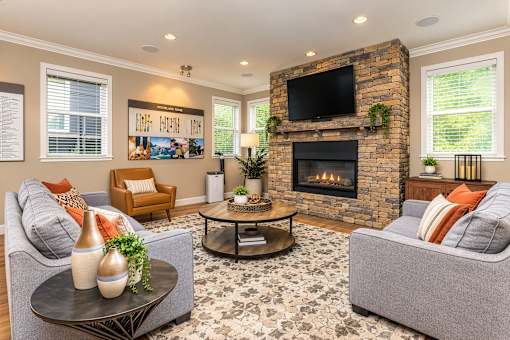 A living room with a grey couch, a brown chair, a coffee table, and a fireplace.