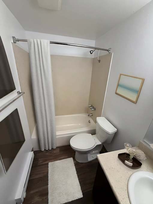 A bathroom with a toilet, sink, and bathtub.