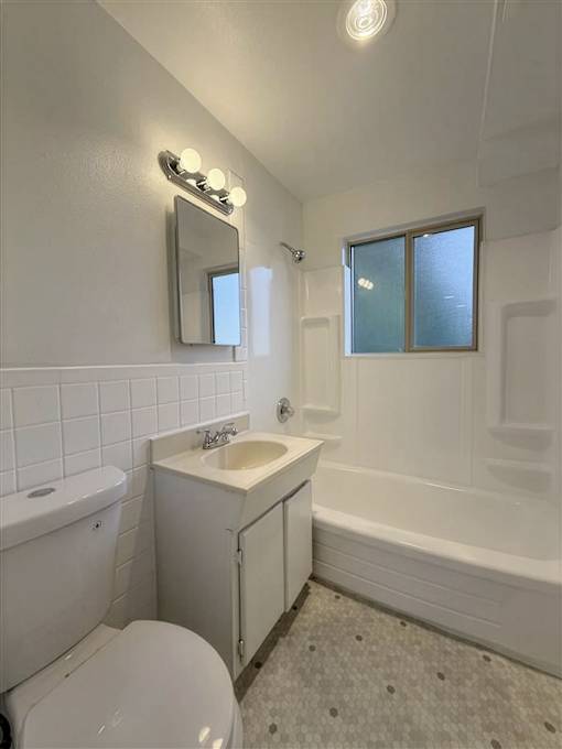 A white bathroom with a toilet, sink, and tub.