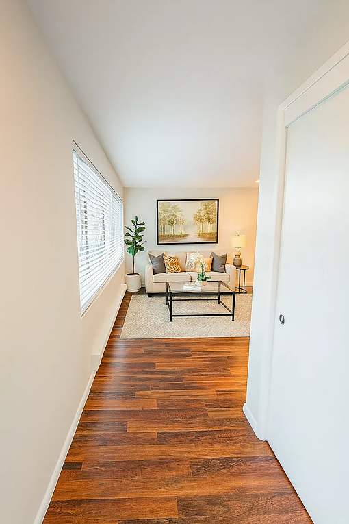 A hallway with a couch and a painting on the wall.