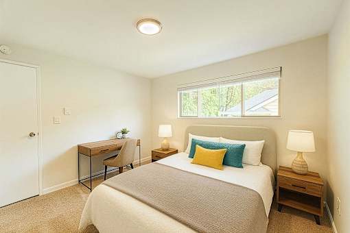 A bedroom with a bed, desk, and chair.