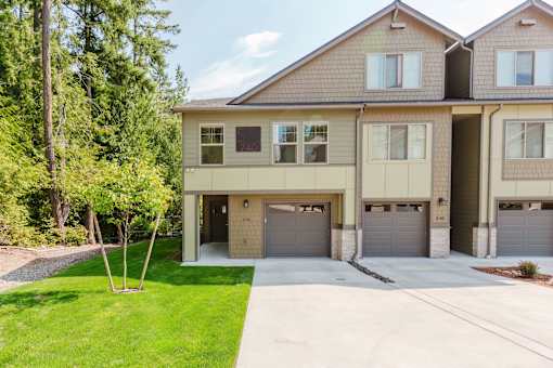 A two-story house with a garage and a driveway.