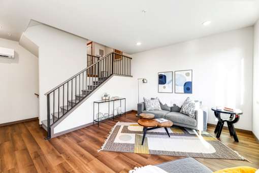 A living room with a staircase and a couch.