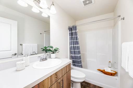 A white bathroom with a white toilet, sink, and bathtub.