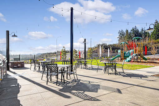 A playground with a slide, swings, and tables.