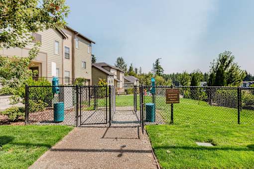 A gated entrance to a residential area with a signboard.