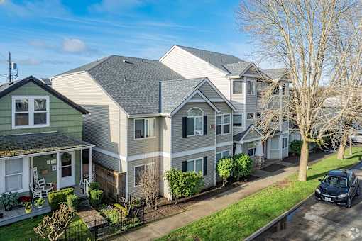 A row of houses with a car parked in front of the last one.